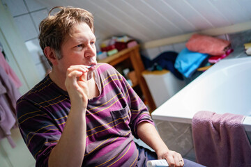 Man doing morning bath routine, brushing teeth, shaving and washing hair.