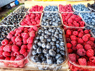 Fresh berries for sale at a market stand during a sunny day in summer