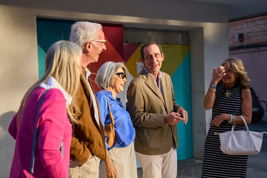 Group of senior friends talking and laughing outdoors