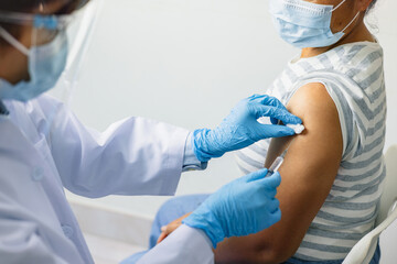 woman is getting  shot from  nurse