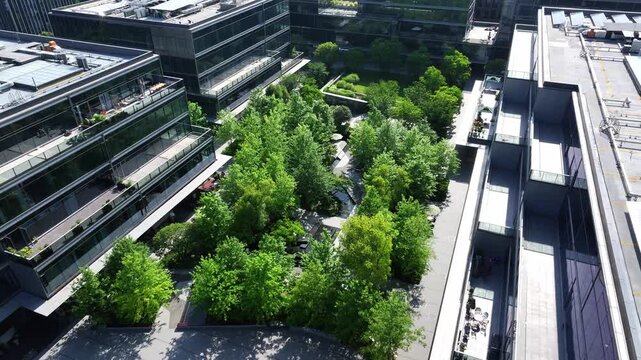 Aerial view of modern architectural complex with lush green trees between buildings