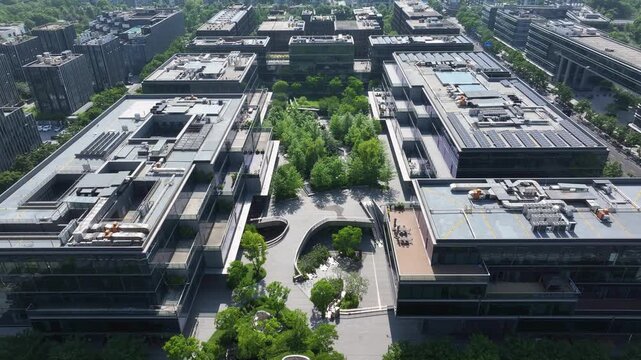 Aerial view of a modern campus with greenery surrounding architectural complexes