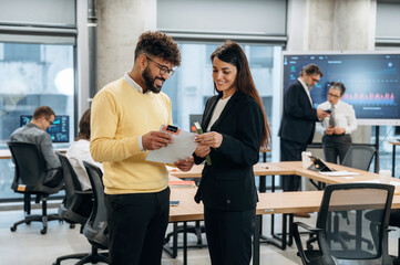 Business professionals engaged in collaborative discussion while reviewing documents in a modern office environment, showcasing teamwork and innovation in action