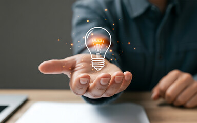Hand holding glowing light bulb idea