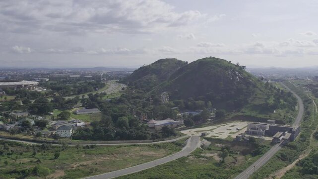 Aerial view of Zuma Rock and Millennium Park, where lush greenery meets the city skyline, creating a vibrant contrast, Magicland, Nigeria.