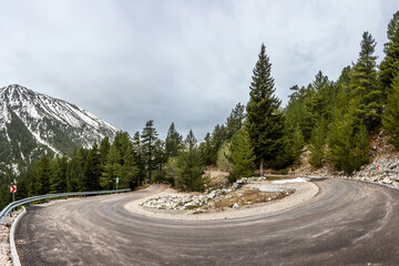 A steep turn on the paved mountain road from Bansko to Vihren hut. Minter cloudy day in Pirin national park, Bulgaria.