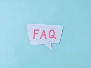 FAQ written on speech bubble on light blue background. Business concept 