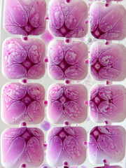 Bright purple frozen liquid in ice cube mold close up