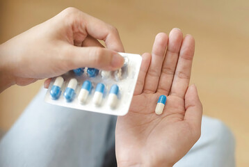 Hand holding pills and blister pack.