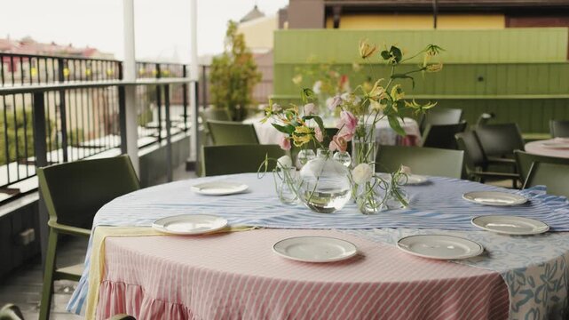 brunch table with plates and vase gingham and floral linens layered chargers clear glass vases delicate blooms