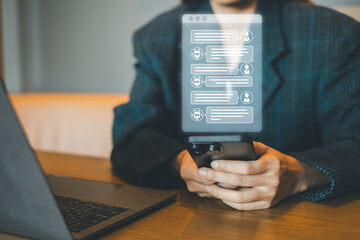 A business professional using a smartphone for digital communication in a modern office setting with a laptop.
