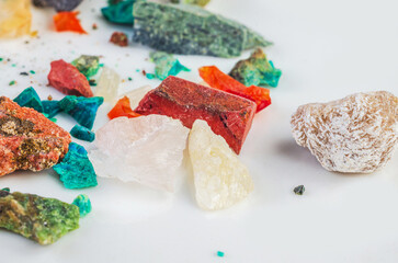 Assortment of colorful mineral rocks and crystals scattered on a white surface
