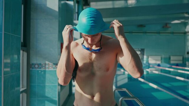 man swimmer dresses cap and swimming goggles.