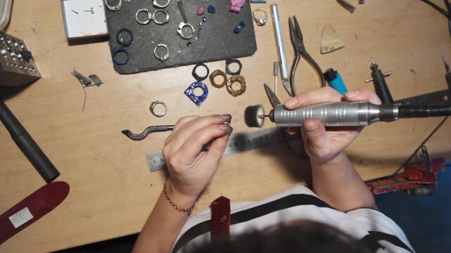 The girl works on a jewelry in the workshop
