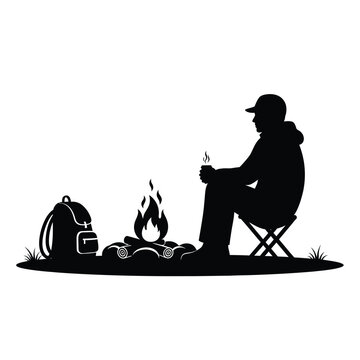 Man sitting by campfire with backpack silhouette relaxing outdoor