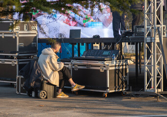 sound engineer sits in front of the equipment waiting to perform on stage