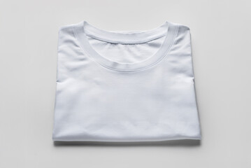 White T-shirt with shadow, folded, front view, isolated on white background. Mockup
