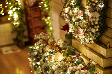 Cozy Christmas interior with festive garland lights and beautifully decorated holiday wreath on a brick fireplace. Warm home atmosphere, holiday spirit, winter celebration and family comfort