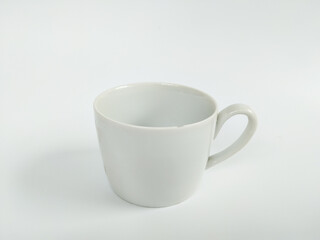 A minimalist studio photograph of an empty white ceramic mug placed against a clean white background.