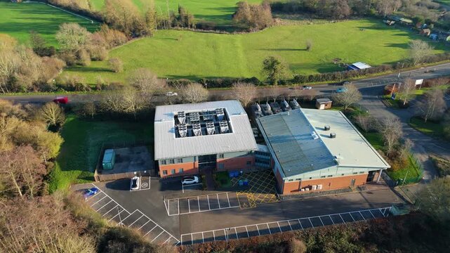 Aerial view of the Six Degrees data centre surrounded by lush green fields and roads with vehicles, Redditch, Redditch, United Kingdom.