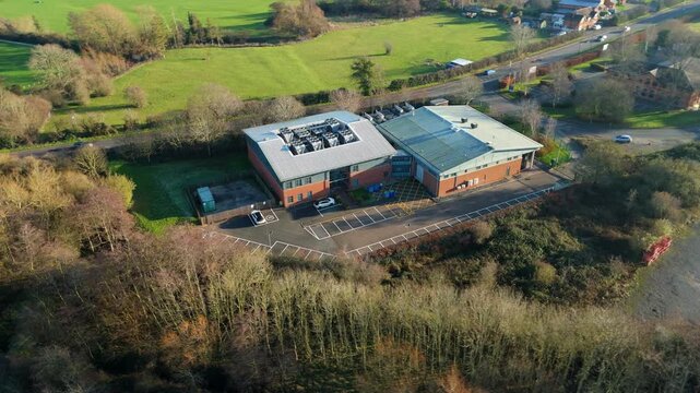 Aerial view of the Six Degrees data centre with its grey roof, surrounded by green spaces and trees, contrasting beautifully, Redditch, United Kingdom.