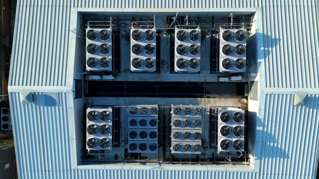 Aerial view of the Six Degrees data centre roof arrayed with cooling units casting shadows on the ridged metallic surface, Redditch, United Kingdom.