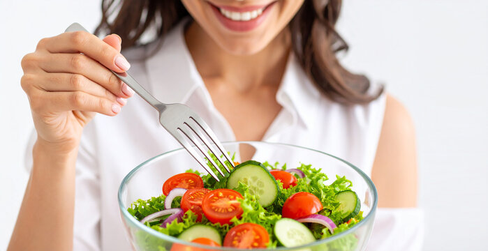Close up de una mujer feliz comiendo ensalada fresca con tomate y lechuga, concepto de alimentaci&oacute;n saludable, dieta equilibrada, h&aacute;bitos de vida sana y control de peso, en fondo blanco