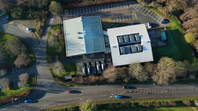 Aerial view of the Six Degrees data centre with its symmetric rooftop array, near a road with moving cars, Redditch, Redditch, United Kingdom.
