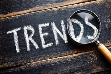 Analyzing trends through a magnifying glass on a wooden surface