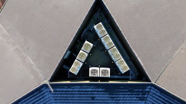 Aerial view of a triangular roof section adorned with multiple HVAC units, creating a geometric pattern against the gray roof, Warwick, England, United Kingdom.