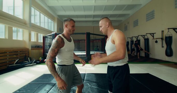 Close-up of two mixed martial artists practicing basic techniques.