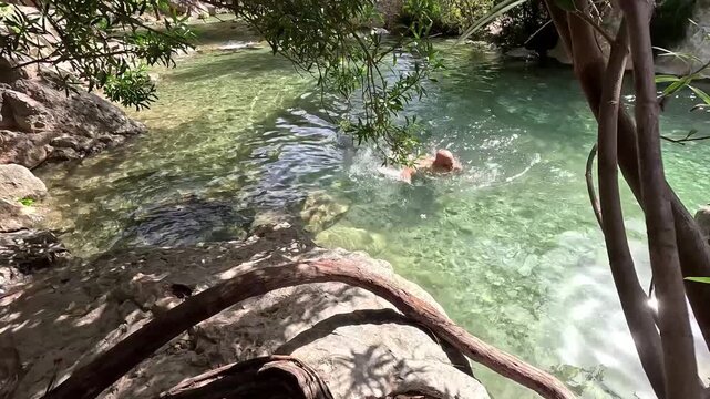 Hombre nadando hacia la orilla en las Fuentes del Algar