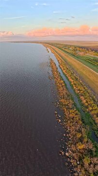 Aerial view of Lake Okeechobee's vast waters meeting the horizon under a pastel sky, a serene landscape of nature's beauty, Lake Okeechobee, Florida, United States.