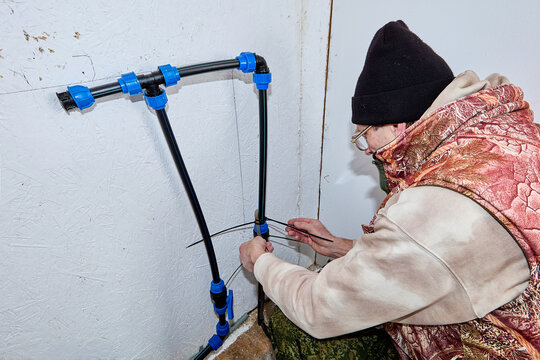 Installation of heating cable on incoming pipe in winterized rural house.