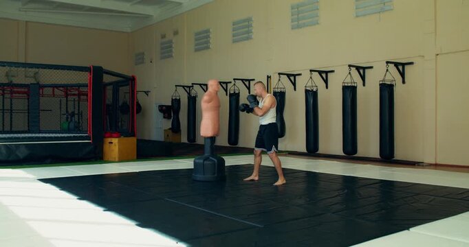 MMA fighter using a training dummy during training.