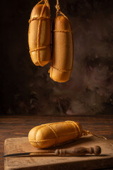 Provolone cheese, wonderful smoked provolone cheese on rustic wood and accessories, abstract background, selective focus.