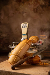 Provolone cheese, wonderful smoked provolone cheese on rustic wood and accessories, abstract background, selective focus.