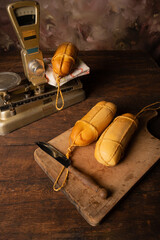Provolone cheese, wonderful smoked provolone cheese on rustic wood and accessories, abstract background, selective focus.