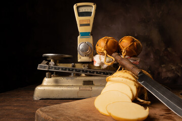 Provolone cheese, wonderful smoked provolone cheese on rustic wood and accessories, abstract background, selective focus.
