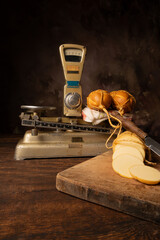 Provolone cheese, wonderful smoked provolone cheese on rustic wood and accessories, abstract background, selective focus.
