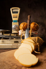 Provolone cheese, wonderful smoked provolone cheese on rustic wood and accessories, abstract background, selective focus.