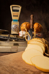 Provolone cheese, wonderful smoked provolone cheese on rustic wood and accessories, abstract background, selective focus.
