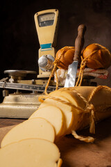 Provolone cheese, wonderful smoked provolone cheese on rustic wood and accessories, abstract background, selective focus.