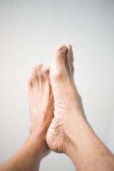 Fototapeta premium Close-up of senior man foot on white background with copy space