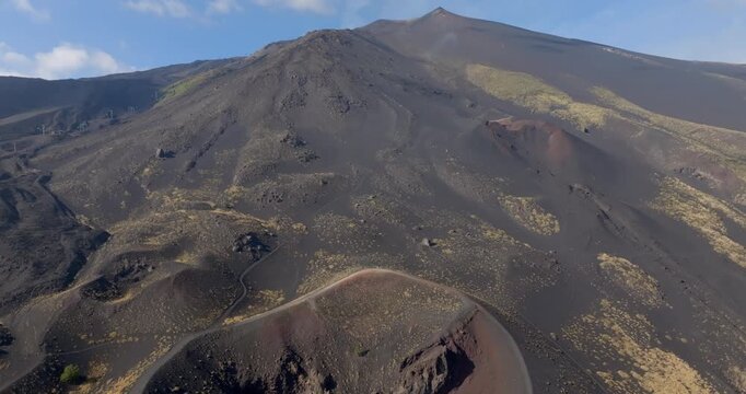 Panorama of the summit of Mount Etna in Sicily, Southern Italy. It is the highest active volcano in Europe. In foreground is the southern crater of the volcano Etna. It is a sunny summer morning.