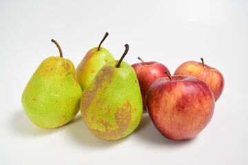 Green pears and red apples on a white background
