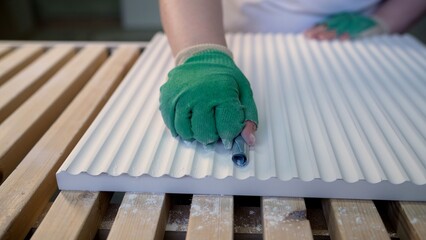 Furniture factory worker sanding corrugated mdf panel by hand