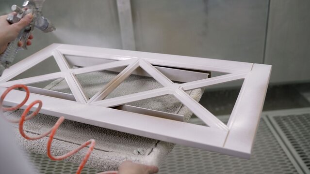Automated spray painting robot arm applying white paint