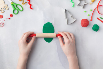 Play dough and Christmas decorations. Little child hands creating Christmas crafts. Holiday Art Activity for Kids. Sensory play for toddlers.