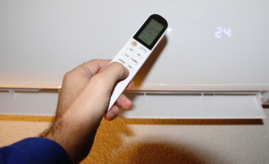 Mando a distancia de aire acondicionado y mano encendiendo m&aacute;quina fr&iacute;o y calor 